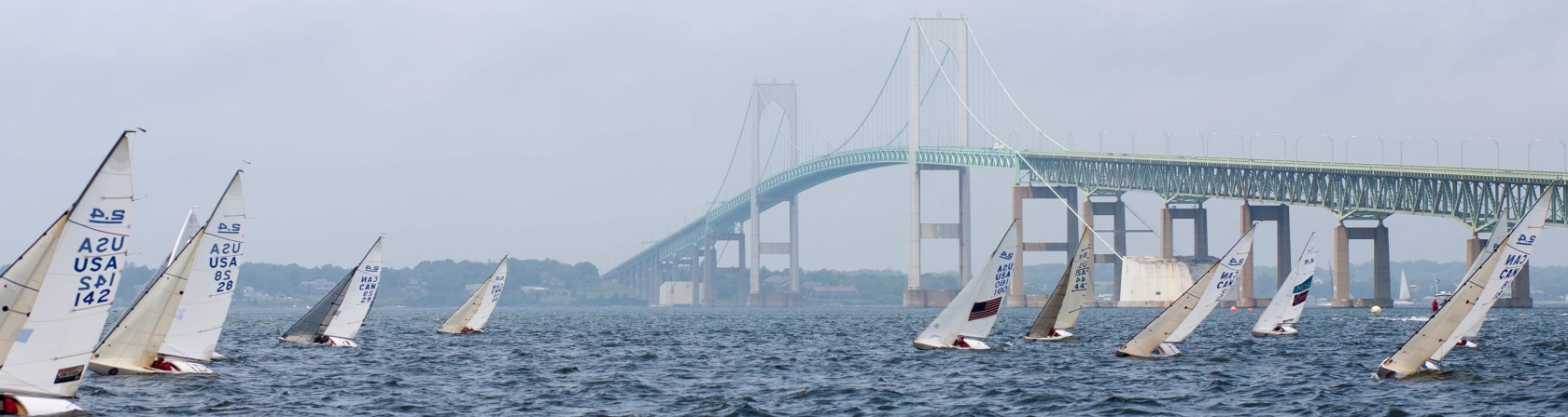 The Clagett fleet of 2.4mRs sail upwind with the Newport Bridge in the background